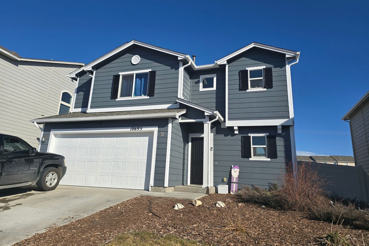 Blue-gray two-story home with white gutters and a finished shingle roof